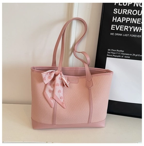 Détail du sac cabas rose tissé avec bordure en cuir et foulard en soie décoratif à cœurs rose