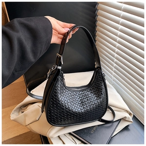 Close-up of black woven hobo bag with adjustable strap and polished silver buckle