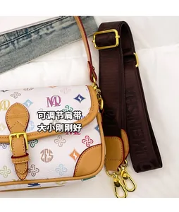 Detail of adjustable wide fabric strap and colorful patterned tote messenger bag