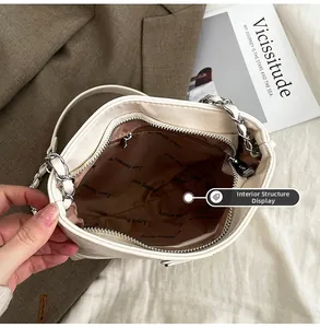 Detailed top view of the bucket bag interior featuring brown lining and zipper pocket