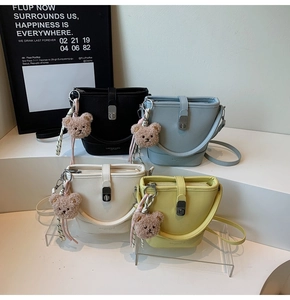 Détail de quatre sacs seaux en cuir grainé avec de jolis pendentifs ours en peluche