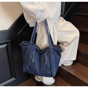 Detail of vintage denim tote bag with dual front zipper pockets and long pull cords