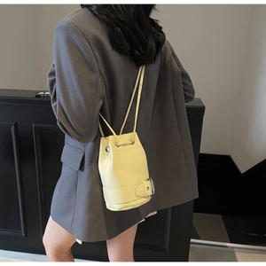 Détail du sac seau crème avec cordon de serrage et boucle porté par un mannequin