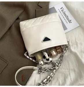 Macro view of beige quilted bucket bag showing spacious interior with cosmetics and phone