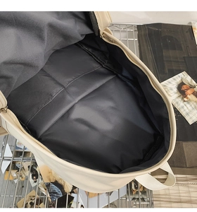 Top view of minimalist beige backpack interior showing spacious black polyester lining