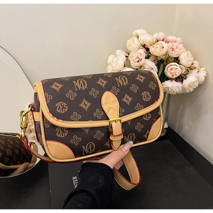 Detail of vintage monogram crossbody bag with gold hardware and brown leather trim