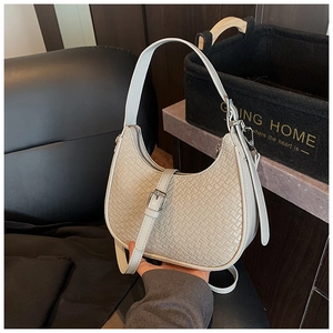 Close-up of woven texture and metal buckle on the beige crescent hobo shoulder bag