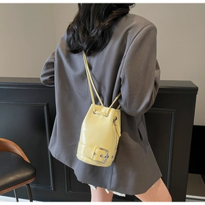 Détail macro du sac seau en cuir jaune brillant avec fermeture étoile et sangle à boucle