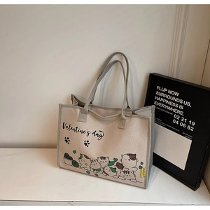 Detailansicht des geräumigen Innenraums und Katzenprints auf der beigen Canvas-Tasche