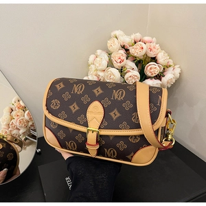 Detail of vintage monogram crossbody bag with leather trim and gold buckle closure