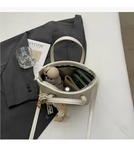 Vista interna della borsa a secchiello beige con grande capacità per telefono e ombrello