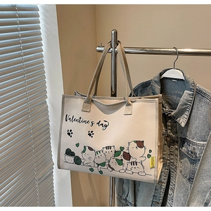 Detailaufnahme von Cartoon-Katzen-Print und Valentine's Day Text auf beiger Canvas-Tasche