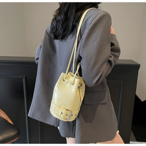 Détail du sac seau jaune vif avec fermeture à cordon et bandoulière à œillets argentés