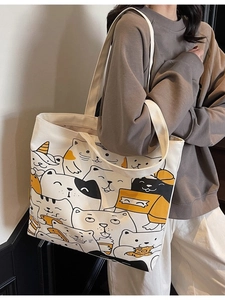 Large white canvas tote bag with dense cartoon cat prints and long shoulder straps