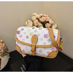 Detail of white leather saddle bag with colorful monogram and gold metal clasp