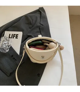 Intérieur spacieux du sac seau blanc cassé montrant les articles et le rangement