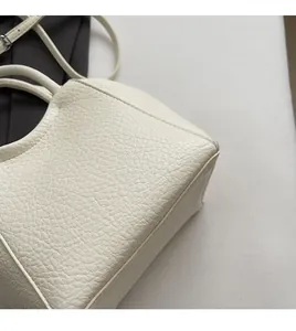 Primer plano de bolso cubo blanco con textura de lichi suave y material de cuero de calidad