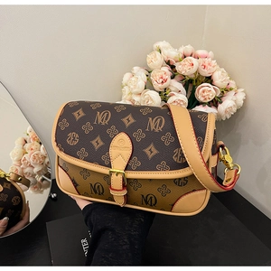 Detail view of vintage monogram crossbody bag with brown leather trim and gold hardware