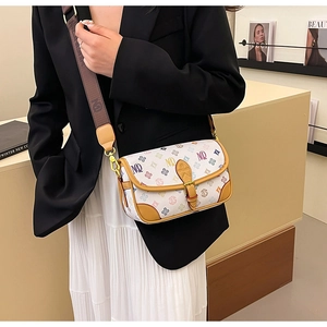 Detail of colorful letter patterns and brown leather trim on a stylish crossbody bag