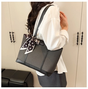 Détail du cabas en tissu gris avec bordure en cuir noir et foulard décoratif à cœurs