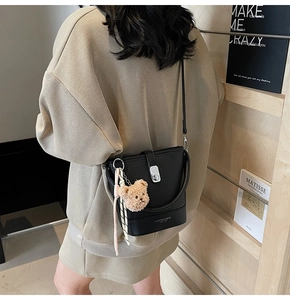 Détail du sac seau noir en cuir avec boucle argentée et pendentif ours en peluche