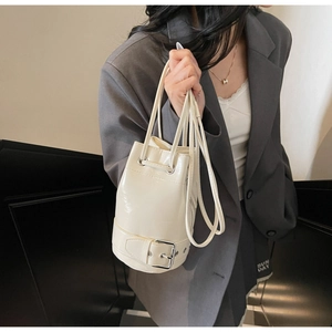 Détail du sac seau crème avec cordon de serrage et boucle argentée brillante