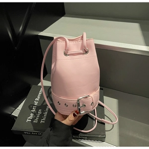 Détail du sac seau rose clair avec fermeture à cordon et boucles argentées