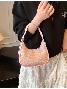 Chic pink crescent hobo bag with crocodile texture shown worn as a stylish underarm bag