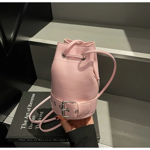 Détail du sac seau rose clair avec fermeture à cordon et boucles métalliques argentées