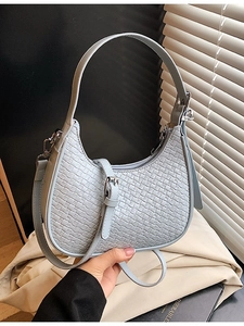 Chic light blue woven crescent shoulder bag with fine texture and slim handle