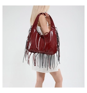 Detailed view of oversized burgundy hobo bag with long black fringe tassels