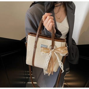 Borsa a secchiello intrecciata beige con finiture in pelle marrone e fiocco in pizzo