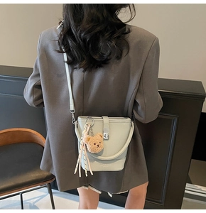 Détail du sac seau vert menthe avec texture litchi et pendentif ours mignon inclus