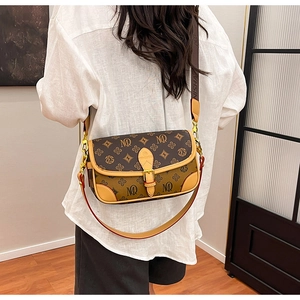 Detail of vintage patterned crossbody bag with gold buckle and wide NISHAN shoulder strap