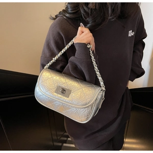 Detail of silver metallic quilted bag featuring a classic twist lock and chain strap