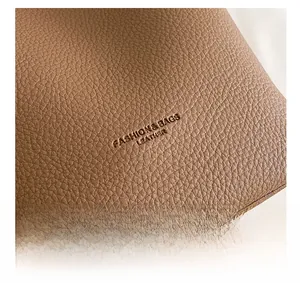 Macro shot of brown lychee grain leather texture with embossed fashion text detail
