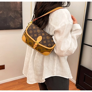 Detailed view of vintage monogram crossbody bag with metallic buckle and leather strap