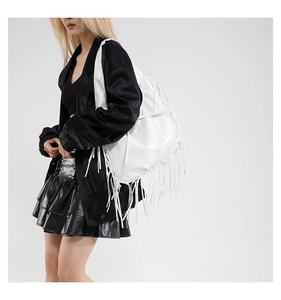 Detailweergave van grote witte glanzende shopper met decoratieve lange franjes