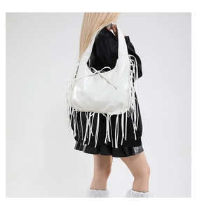 Detailed view of white faux leather tote bag featuring long Y2K fringe and a bow accent