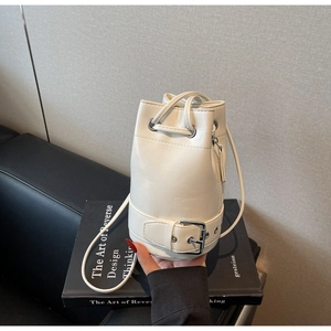 Détail du sac seau crème montrant le cordon de serrage et la sangle à boucle en métal