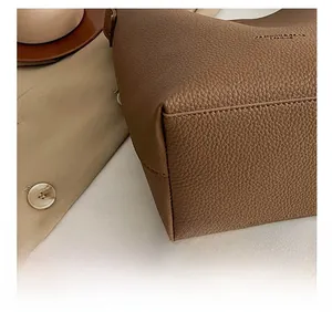 Close-up of precise stitching on brown lychee grain faux leather bucket bag