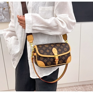 Detail view of a vintage monogram crossbody bag with wide strap and gold buckle hardware