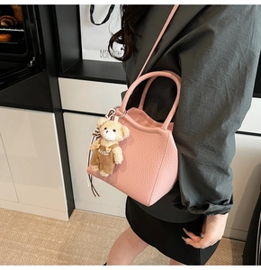 Mini bolso tipo cubo rosa con textura lichi, colgante de osito y herrajes plateados