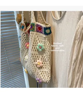 Dettaglio di borsa tote bianca in maglia con fiori 3D all'uncinetto e trama morbida