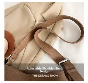 Close-up of adjustable shoulder strap with silver buckle on brown lychee leather bucket bag