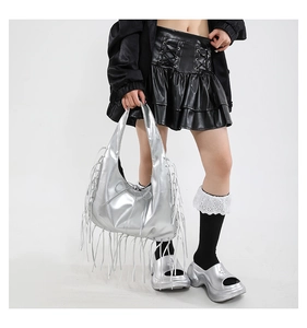Close-up of metallic silver hobo bag featuring long flowing fringe and top handle design