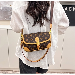 Detail of vintage monogram crossbody bag with brown leather trim and wide strap