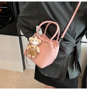 Bolso tipo cubo rosa con textura de lichi, colgante de oso y correa ajustable
