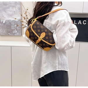Detail of vintage monogram shoulder bag featuring leather trim and flap closure on model