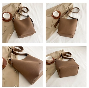 Detail view of brown lychee grain bucket bag with adjustable strap and metal studs
